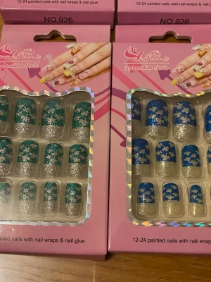Splendid Nail press-on naglar glitter - Flera paket press-on naglar från Splendid Nail i olika färger: blå, grön, röd och svart. Alla naglar har silverglittrig tipp och vita blommönster. Innehåller 12-24 naglar per paket samt nagellim. Perfekt för dig som vill ha snygga och trendiga naglar snabbt. 49kr/paket . Samma frakt 