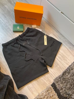Svarta Essentials shorts-L - Svarta shorts från Essentials Fear of God med elastisk midja och snörning. Storlek L, toppskick aldrig använda, priset kan diskuteras! Vid hjälp av frågor skicka gärna ett meddelande!