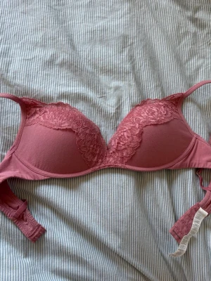 Intimissimi push up bh - Snygg rosa bh med vadderade kupor och fina spetsdetaljer upptill. Bh:n har justerbara axelband och hakknäppning bak. Har inte kommit till andvändning.
