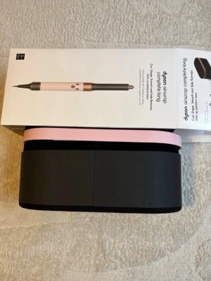 Dyson Airwrap Complete Long rosa - Säljer en Dyson Airwrap Complete Long i snygg rosa och svart design. Setet innehåller flera stylingtillbehör för olika hårtyper och en elegant förvaringsväska. Perfekt för dig som vill fixa håret med värmeverktyg av hög kvalitet.