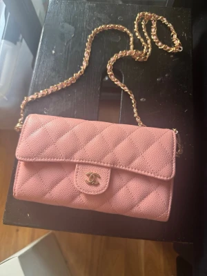 Rosa quiltad handväska - Supersnygg rosa quiltad handväska med guldfärgad kedjerem. Väskan är tillverkad i strukturerat läder.  Perfekt för dig som vill ha en lyxig och trendig accessoar. 18*11 cm