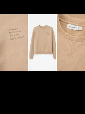 Beige sweatshirt från motesandthread - Beige sweatshirt i mjuk bomull från motesandthread. Tryck på bröstet med texten 'a woman needs a man like a fish needs a bicycle'. Klassisk rund halsringning och ribbade muddar vid ärmslut och nederkant. Perfekt för en chill och avslappnad stil.