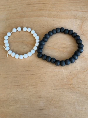 Svart pärlarmband i trä - Säljer ett stilrent svart armband med runda träpärlor trädda på elastisk tråd. Perfekt för dig som gillar enkel och naturlig design. Passar både till vardagslooken och när du vill addera en subtil detalj till din outfit.