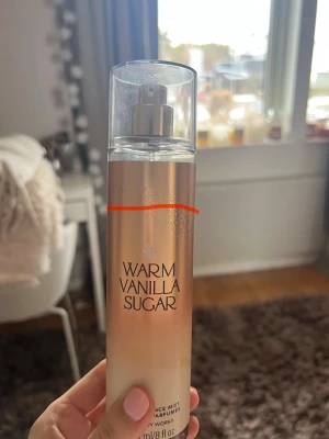 Warm Vanilla Sugar Body Mist - En body mist från Bath & Body Works med doften Warm Vanilla Sugar. Fast pris. Fylld upp till sträcket, det är lite svårt att se precis hur mycket som är kvar eftersom flaskan inte går att se genom. Flaskan är genomskinlig med en mjuk beige och guldig ton, och har en silvrig spraypump samt ett genomskinligt lock. Perfekt för dig som gillar söta och varma vaniljtoner.