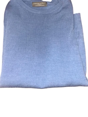 Ljusblå stickad tröja från Primark - En stilren ljusblå stickad tröja från Primark med rund halsringning och långa ärmar. Tröjan är i mjukt material och har en klassisk, enkel design som passar perfekt till jeans eller kjol.