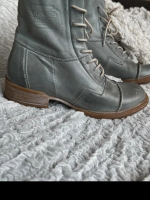 Mint gröna läderkängor från Ten Points - Snygga mint gröna kängor i äkta läder från Ten Points med klassisk snörning och robust brun sula. Perfekta för dig som gillar stilrena och tidlösa boots med en cool vintagekänsla. Passar till både jeans och kjol för en trendig look. Äkta läder från Ten Points – väldigt bekväma och hållbara kvalitetsskor.