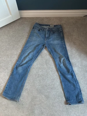 Blå raka jeans från tiger of sweden - Säljer ett par morderna och stilrena tiger of sweden jeans, jeansen har en fin blå färg. Jeansen är i st 28/30 och bär stylen meg