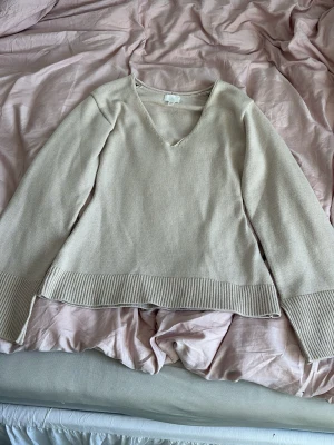 figursydd stickad tröja med v-ringning - Säljer denna extremt fina figursydda stickade tröjan med v-ringning från H&M i strl XS!🌷 toppen uthäver kurvor och är i en varm beige färg, väldigt fin till både vardag och lite finare evenemang! Tröjan är knappt använd och har inga defekter! Packas och postas säkert!📦💓