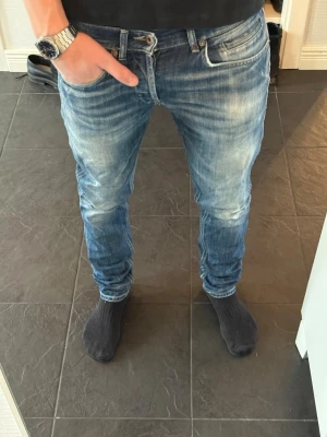 Dondup George jeans - Riktigt snygga ljusblåa jeans från Dondup i stilen George. Jeansen är skinny fit i storlek 31. Jag är 180cm och väger 70kg. Jeansen är lagade av skräddare vid grenen av jeansen vilket kan ses i bild 5, men det ses inte vid användning. Hör av er vid frågor eller funderingar!