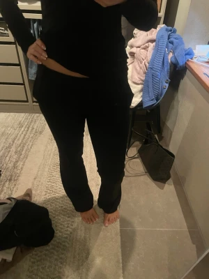 Svarta utsvängda kostymbyxor  - Säljer ett par svarta kostymbyxor  med utsvängda ben. De har låg midja och sitter tight upptill men är vidare nertill. Perfekta för en trendig och uppklädd stil. Byxorna är i nyskick och använda få gånger.