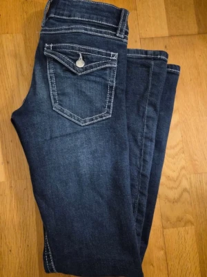 Mörkblå bootcut jeans med kontrastsömmar - Snygga mörkblå bootcut jeans med vita kontrastsömmar från gina tricot. Använd ett par gånger, men inga tecken ellen skavanker på de. Säljer då den inte kommer till användning💕