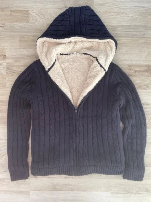 Fodrad stickad cardigan - Otroligt snygg blå fodrad kabelstickad cardigan. Passar fint nu till slutet av vintern och våren. Priset kan såklart diskuteras! Axel till midja är 55cm ungefär. Armhåla till armhåla är 48 cm ungefär. 
