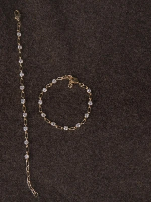 Guldfärgat armband med kristaller  - Säljer guld pläterat armband i 18k med CZ kristaller🌸 Grundmaterialet är mässing!  Om du har frågor om mått mm så är det bara att höra av sig!💗 Det är mitt UF-företag som har sålt dessa smyckena!☺️ Säljer två stycken: 1/2