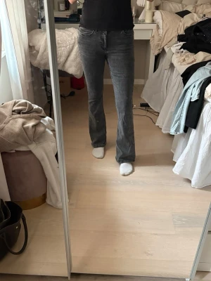 Grå bootcut jeans  - Säljer ett par grå bootcut jeans med medelhög midja. Jeansen är i storlek M. Knappt använda  