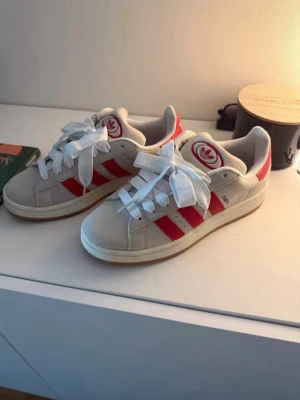 Adidas campus 00s - Snygga Adidas campus 00s i mocka med klassiska röda ränder på sidorna och vit ovandel. Knappt använda