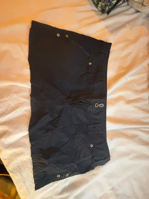Mini cargokjol - Mini cargokjol med flera fickor snygga knappar framtill. Snygg mörkblå färg och cool stil. Klippt lite slarvigt därav priset men inget som syns när man har på sig den!🩷