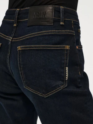 Mörkblå bootcut jeans från NEUW - Mörkblå jeans i bootcut-modell från NEUW med klassiska gula sömmar och femficksdesign. Jeansen har hög midja och är tillverkade i kraftigt denimtyg. Snygg logotyp på bakfickan och läderpatch i midjan. Jeansen har prislappen och har aldrig används (på grund av längden) och är köpta för 1499kr. 