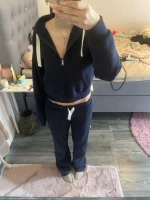 Mörkblå mjukis set - Mörkblått set från Gina tricot med vita snören. Byxorna har två bakfickor med broderad detalj. Mjukt och skönt material perfekt att ha både ute och hemma💗Tröjan är storlek S och byxorna M💗