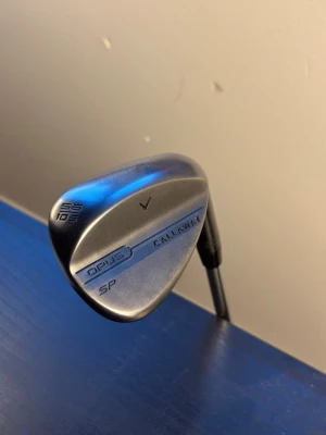 Callaway opus sp 56 - Säljer en nästan helt ny Callaway Opus SP wedge i toppskick. Klubban är endast testad med runt 5 slag, så den är i princip ny. Utrustad med Dynamic Gold Wedge shaft som ger riktigt bra känsla, kontroll och stabilitet i närspelet. Har även ett helt nytt original Callaway-grepp.  Callaway Opus-serien är känd för sin spinn, mjuka känsla och höga kontroll runt greenerna. Perfekt för dig som vill ha en premiumwedge med tour-känsla och riktigt bra precision både vid chippar och inspel.