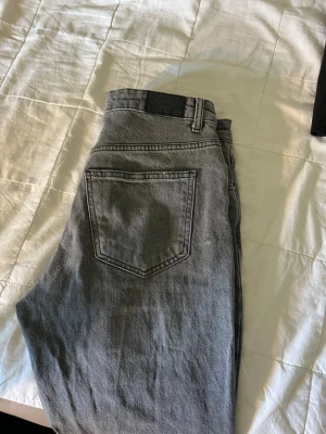 Grå raka jeans med rå kant - Säljer ett par grå jeans med raka ben och råa, fransiga benslut. Jeansen har klassisk femficksdesign och är tillverkade i denim.💗