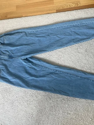 Baggy ljusblå jeans med brodyr - Säljer ett par baggy blå Jens från southpole, använda i princip ingenting och är i väldigt bra skick.
