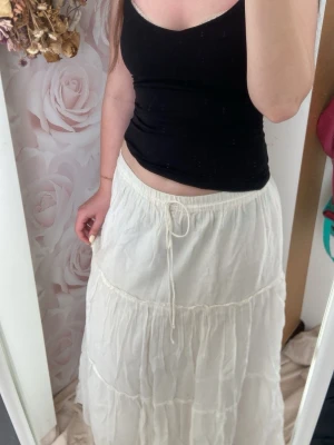 Vit långkjol med snörning från primark - Superfin vit långkjol med volanger och snörning i midjan. Jag är 167 cm och den släpar i marken