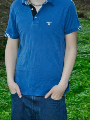 Blå piké t-shirt från Gant - Snygg blå piké t-shirt från Gant med klassisk krage och knappar framtill. Ny-pris 650kr 
