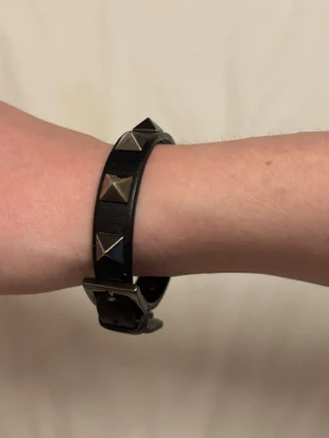 Valentino Garavani leather studded bracelet nero - Ett armband från Valentino Garavani. Färgen Nero, storlek ns. Kvitto på köp från NK finns, kommer med originalask. Använd fåtal gånger, mindre slitage på insidan men relativt gott skick utanför, se bilder. 