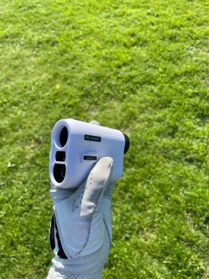 Avståndsmätare från Revasri - Säljer en vit och svart avståndsmätare från Revasri, perfekt för golf eller andra utomhusaktiviteter där du behöver mäta avstånd snabbt och smidigt. Kompakt och lätt att hålla i handen, med tydliga linser och enkel knapp för användning. Väska tillkommer och den funkar utmärkt.