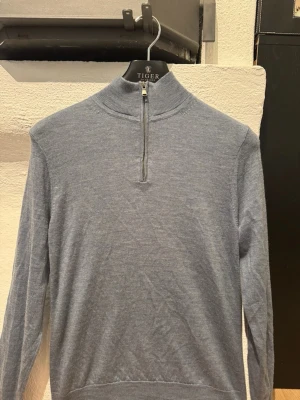 Ljusblå halvzip-tröja  - Ljusblå merino stickad tröja från Trenery med halvzip och hög krage. Perfekt för lager på lager och enkel att matcha med olika stilar.