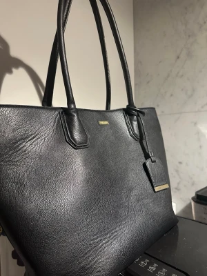 Svart väska - Säljer min  jätte fina svarta väska som är perfekt för skoldator och böcker. Ens rämnan kan vara lite sliten eftersom att den har använts men inget som påverkar alls💕