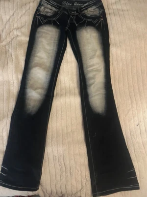 Lågmidjade bootcut jeans från Blue Queen - Säljer ett par blå bootcut jeans från Blue Queen med coola detaljer och markerad tvätt på framsidan för en unik stil. Perfekta för dig som är lite mer alternativ. Pris kan diskuteras!