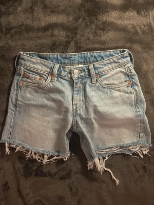 Ljusblå jeansshorts💞 - Säljer ett par ljusblå jeansshorts från weekday med fransig och rå kant nertill.  Perfekta för sommaren och våren. SKRIV ANGÅENDE FRAKT💞