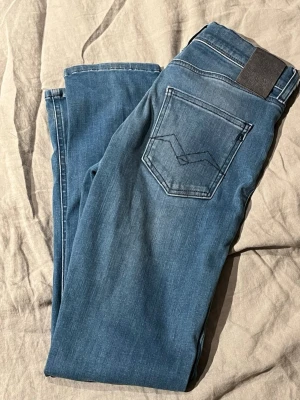 Blå jeans sköna och märke Replay  - Snygga blå och stilren bakficka med dekorativ söm. Jeansen har en mörkgrå patch vid linningen och är tillverkade i ett mjukt denimtyg. Perfekta för en avslappnad och trendig look. Replay 