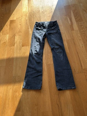 Svarta bootcut jeans från Gina Tricot - Snygga svarta bootcut jeans från Gina Tricot med coola fickdetaljer fram och breda hällor. Jeansen har en klassisk femficksmodell och är tillverkade i denim med lätt tvättad look. Perfekta för en trendig och avslappnad stil. Jag köpte dom för 199kr då dom var på rea 