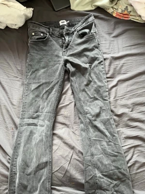 Grå bootcut jeans från 157 - Snygga grå bootcut jeans från 157 med låg midja. Jeansen har klassisk femficksdesign och är tillverkade i denim. Perfekta för dig som gillar en avslappnad men trendig stil. Använda fåtal gånger.
