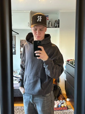 Svart hoodie med rosa tryck  - Säljer en svart hoodie med stort rosa tryck på ryggen. Hoodien har en klassisk huva och en stor magficka framtill. Materialet är mjukt och bekvämt, perfekt för chill dagar. Passar dig som gillar streetwear och grafiska prints.