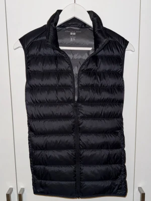 Svart dunväst från Uniqlo - Säljer nu min väst från uniqlo som är i toppskick utan några skador eller defekter.