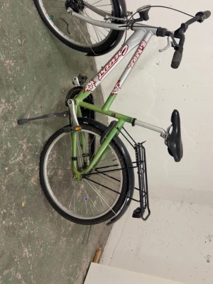 Grön och silver Crescent cykel - Säljer en Crescent cykel i grön och silver med svart pakethållare, stänkskärmar och sadel från Selle Royal. Cykeln har raka styren, dekaler på ramen och kedjeskydd. Perfekt för dig som vill ha en smidig cykel till vardags.