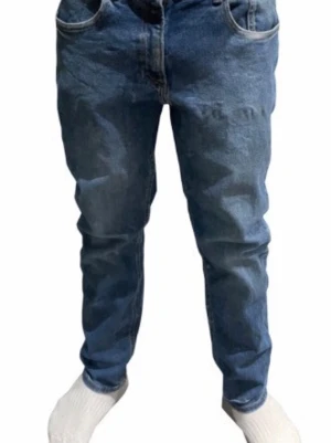 Blå loose fit jeans med raka ben - Säljer ett par klassiska blå jeans i loose fit-modell med raka ben och normal midja. Jeansen har fem fickor och stängs med dragkedja och knapp. Perfekta för en avslappnad och trendig stil. Materialet är kraftig denim i bomull.