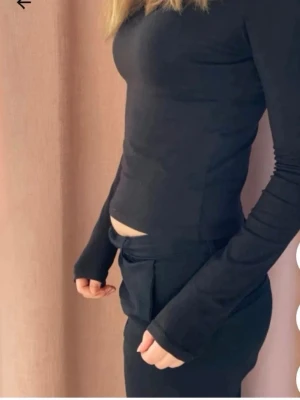 Svart långärmad croppad topp - Svart långärmad topp, relativt åtsittande så att figuren främjas. Väldigt bra skick