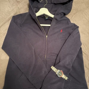 Blå hoodie Ralph Lauren - Mörkblå hoodie från Ralph lauren. Skick 7/10. Den har vissa solblekningar men syns inte jätte mycket. 