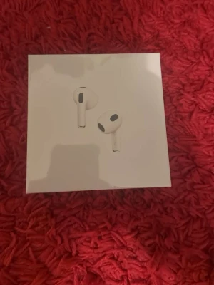 Apple AirPods 3rd generation - Trådlösa vita hörlurar från Apple, modell AirPods 3rd generation. Snygg och stilren design med rundade former och korta stjälkar. Kommer i originalförpackning och är tillverkade i plast. Perfekta för musik, samtal och vardagsbruk.