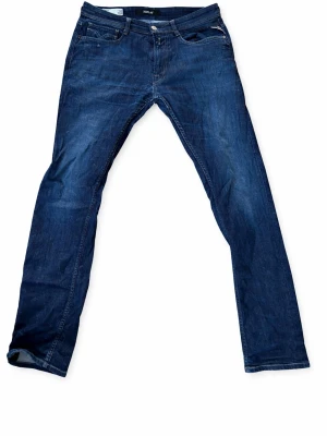 Mörkblå jeans från replay - Snygga mörkblå jeans från replay med klassisk femficksdesign och raka ben. Jeansen har en stilren look med diskreta sömmar och är tillverkade i denim. Perfekta för en avslappnad och trendig stil.