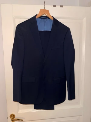 Mörkblå kostym (Dressmann) - Snygg mörkblå kostym från Dressmann i slim fit-modell. Kavajen är storlek 46 och byxorna 28/32