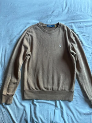 Beige sweatshirt från Polo Ralph Lauren - Tröja från Polo Ralph Lauren med rund halsringning och långa ärmar. Säljs till 71% lägre pris än originalpriset