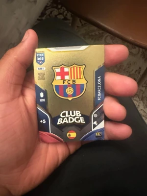 Panini FIFA 365 FC Barcelona Badgekort - Samlarobjekt från Panini FIFA 365-serien, ett klubbmärke-kort för FC Barcelona. Kortet har klubbens klassiska färger och logga på framsidan och FIFA 365 Adrenalyn-design på baksidan. Perfekt för dig som gillar fotboll och samlarkort.