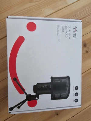 Fifine USB mikrofon med stativ - Säljer en svart Fifine USB-mikrofon med stativ och popfilter. Mikrofonen har en rundad form och är tillverkad i metall med ett mesh-galler framtill. Perfekt för streaming, gaming eller podd. Enkel att koppla in via USB.
