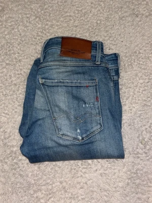 Replay jeans med slitningar - Replay anbass, slimfit, längd 32, bredd 28-31. Skick 8/10 dem är använda men har inga defekter, riktiga replay köpta för 2000kr, om du har några frågor skriv i dm!