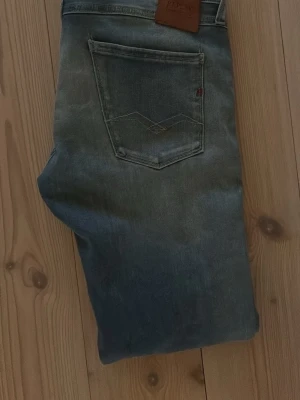 Replay blå jeans - Säljer ett par klassiska blå jeans från Replay med raka ben. Jeansen har fem fickor och en ikonisk bakficka med broderad detalj. Jeansen är slim fit. Perfekta till en avslappnad stil och tillverkade i slitstark denim. Storleken är 28/32. Hör av er vid frågor o kom med prisförslag!